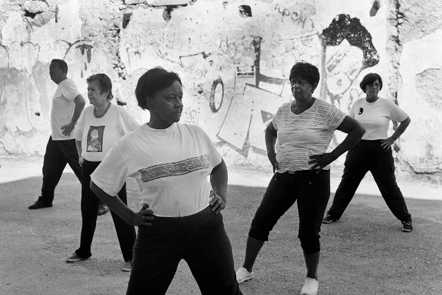 Black and white image of a group of older Cubans taking an exercise class.